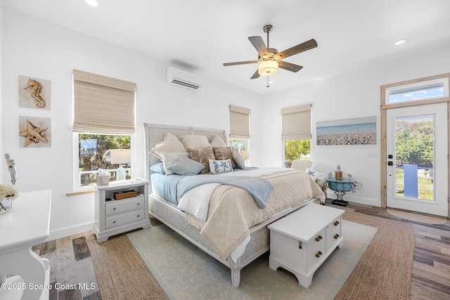 bedroom with recessed lighting, wood finished floors, access to outside, a wall mounted air conditioner, and baseboards