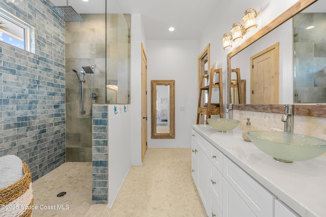 bathroom with double vanity, walk in shower, a sink, and recessed lighting