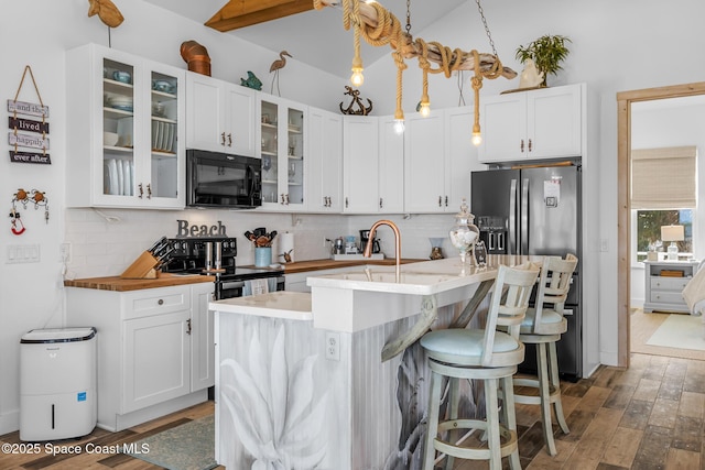 kitchen featuring white cabinetry, dark wood finished floors, backsplash, and black appliances