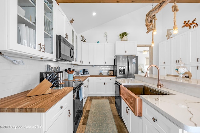 kitchen with dark wood-style floors, tasteful backsplash, white cabinets, a sink, and black appliances