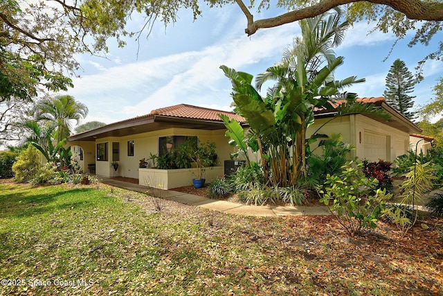 view of property exterior featuring a tile roof, a lawn, an attached garage, and stucco siding