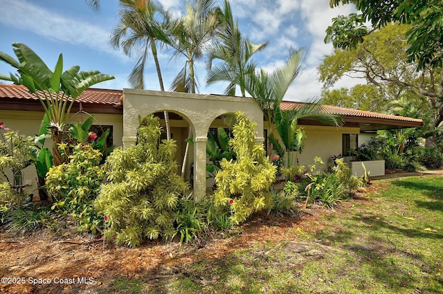 exterior space featuring a tiled roof and stucco siding