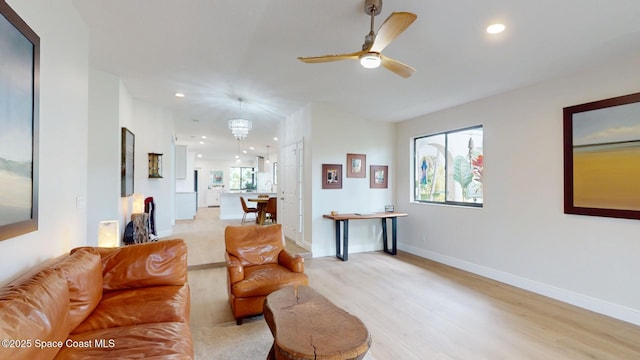 living area with light wood finished floors, ceiling fan, baseboards, and recessed lighting