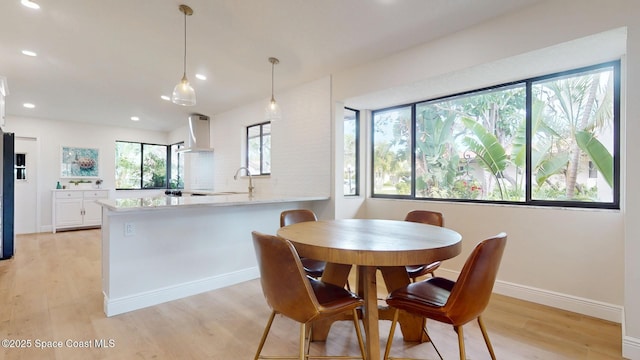 dining area featuring baseboards, light wood-style flooring, and recessed lighting