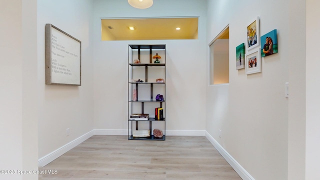 corridor featuring wood finished floors and baseboards