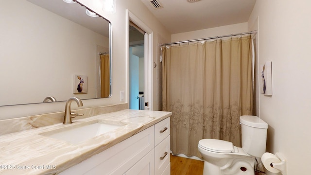 bathroom featuring visible vents, vanity, toilet, and wood finished floors