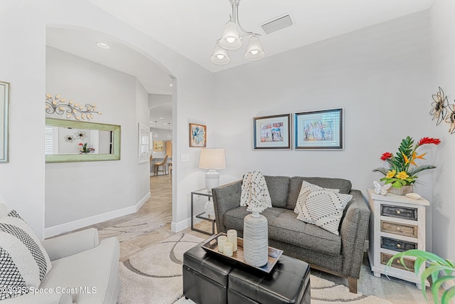 living area featuring visible vents, arched walkways, and baseboards