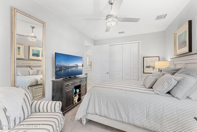 carpeted bedroom with visible vents, a closet, and ceiling fan