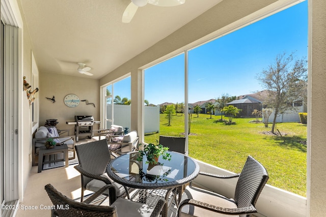 sunroom / solarium featuring a ceiling fan