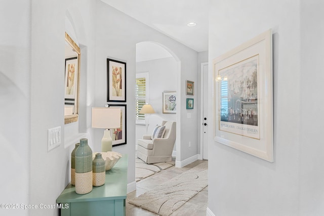 hall with recessed lighting, baseboards, and arched walkways