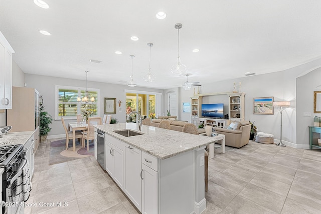 kitchen featuring an island with sink, a sink, range with gas cooktop, ceiling fan with notable chandelier, and stainless steel dishwasher