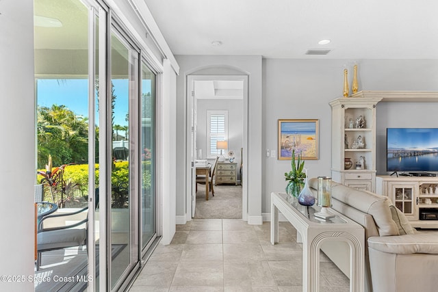 interior space featuring light tile patterned flooring, visible vents, and baseboards