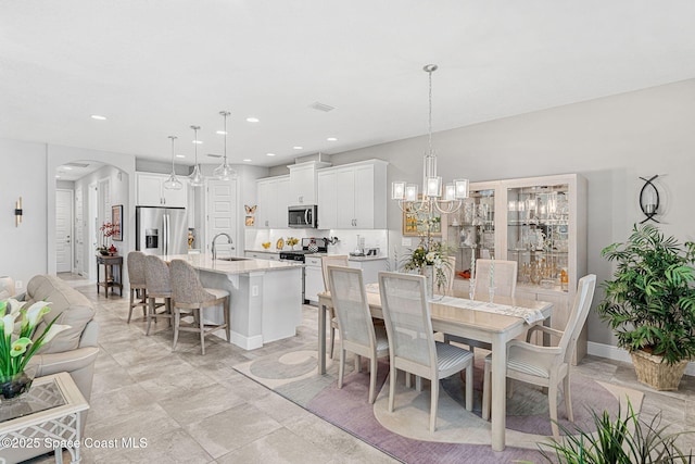 dining room with recessed lighting, visible vents, arched walkways, and a chandelier