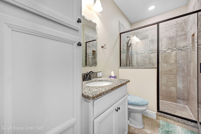 bathroom with vanity, a shower stall, toilet, and tile patterned flooring