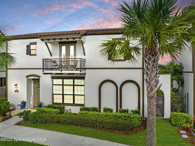 7072 Mercado Ln, Melbourne, FL 32940 - mediterranean / spanish-style home featuring a tile roof, a balcony, french doors, fence, and stucco siding