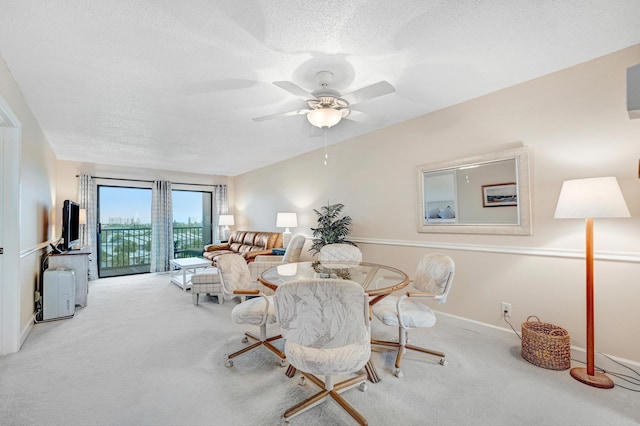 dining space featuring carpet floors, a textured ceiling, baseboards, and a ceiling fan