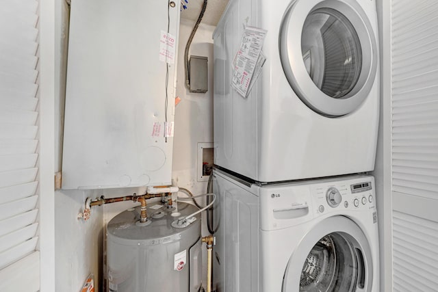 washroom with stacked washer / drying machine, laundry area, and electric water heater