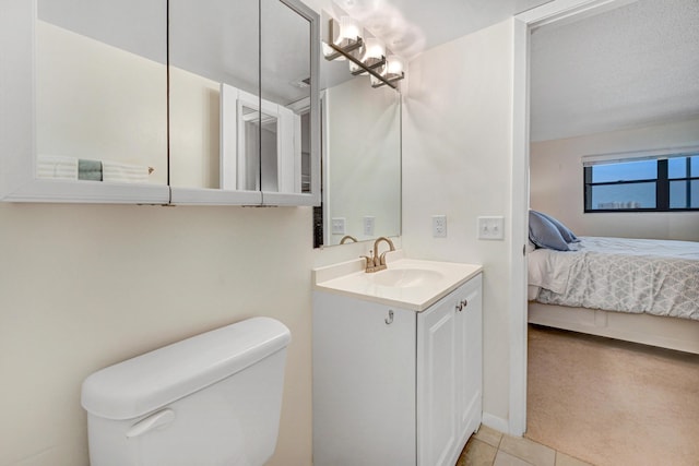 ensuite bathroom featuring tile patterned flooring, vanity, toilet, and ensuite bathroom