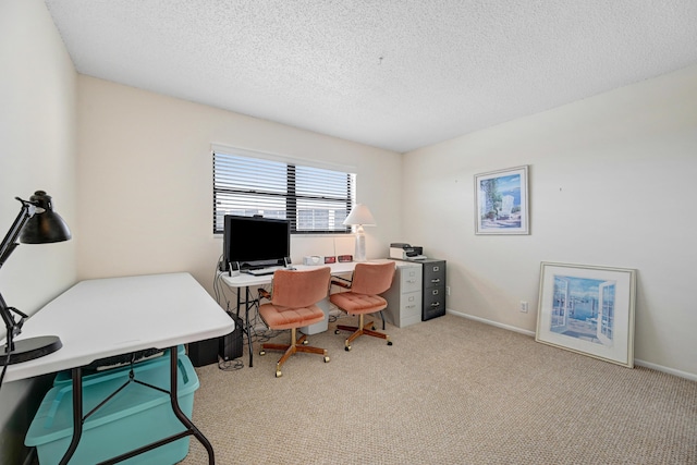 carpeted office space featuring baseboards and a textured ceiling