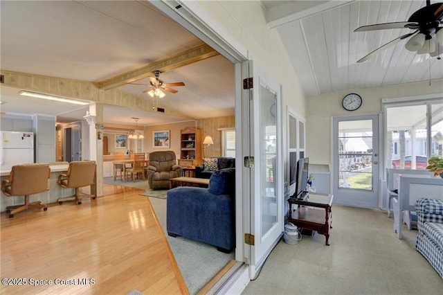 living area with lofted ceiling with beams, ceiling fan, and wood finished floors