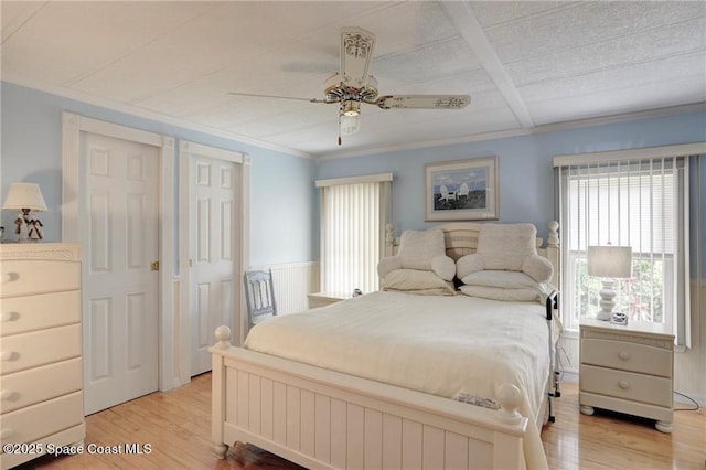 bedroom with a ceiling fan, light wood-type flooring, and crown molding