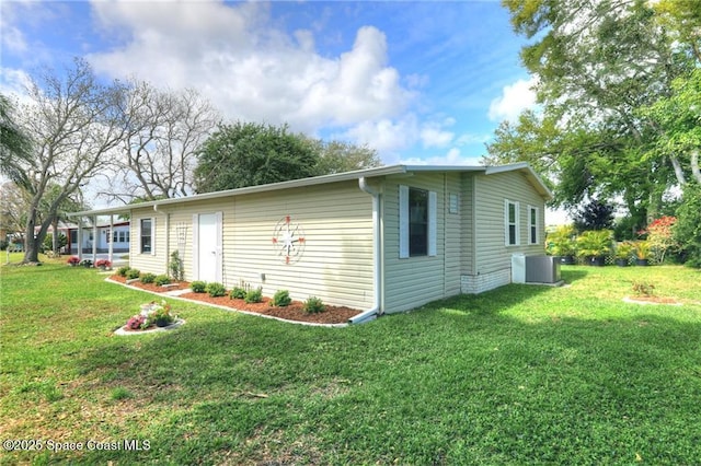 view of front of property with central AC unit and a front lawn