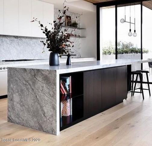 bar featuring decorative backsplash, a dry bar, and light wood finished floors