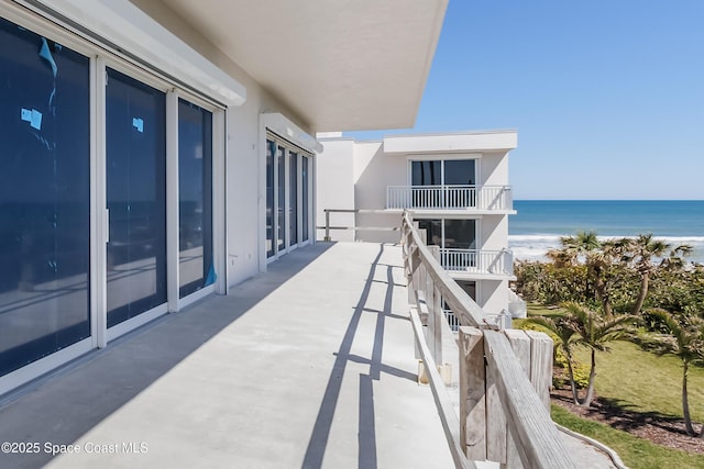 balcony with a water view and a beach view