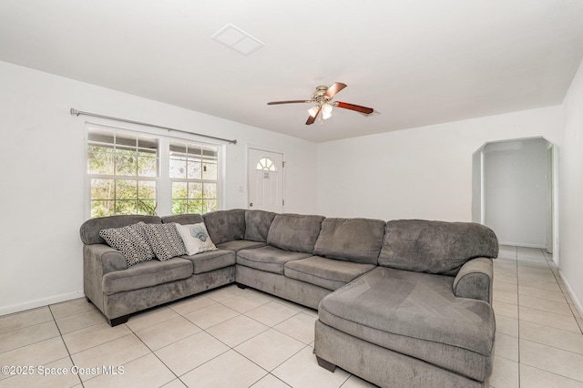 living room with light tile patterned floors, ceiling fan, and baseboards