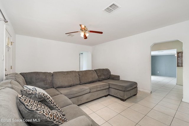 living room with visible vents, arched walkways, a ceiling fan, and light tile patterned flooring