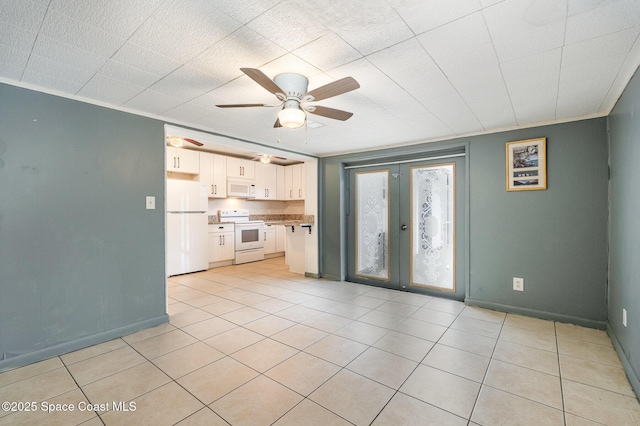 interior space with a ceiling fan, french doors, crown molding, and baseboards