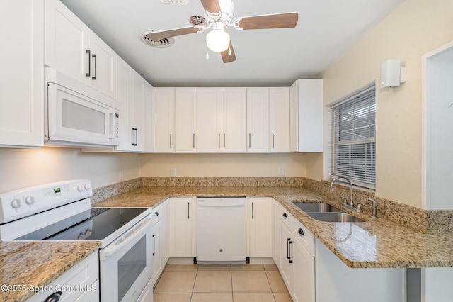 kitchen featuring white appliances, light tile patterned flooring, a sink, and white cabinets