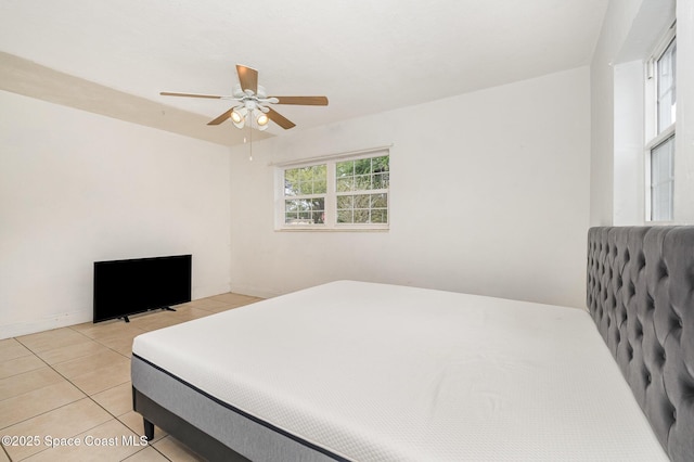 bedroom featuring ceiling fan, baseboards, and light tile patterned flooring