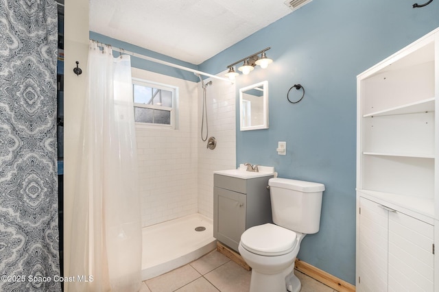 bathroom with toilet, vanity, baseboards, a shower stall, and tile patterned floors