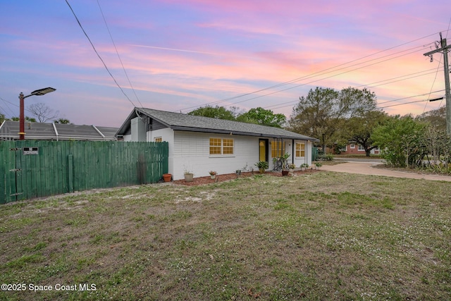 view of front of property with a yard and fence