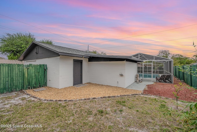 rear view of property featuring a fenced in pool, concrete block siding, a patio area, a lanai, and a fenced backyard