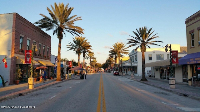 view of street featuring curbs, sidewalks, and street lights