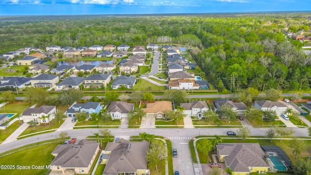 drone / aerial view featuring a residential view and a wooded view