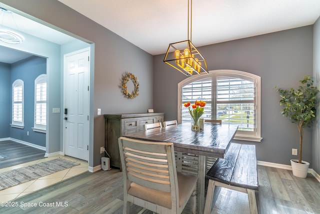 dining space featuring light wood-style flooring, baseboards, and a wealth of natural light