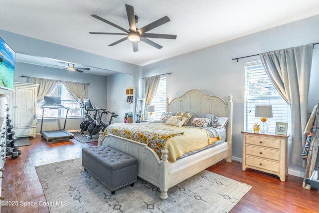 bedroom featuring a ceiling fan, baseboards, and wood finished floors