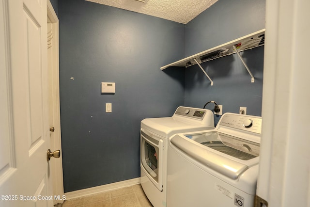 laundry room with light tile patterned floors, a textured ceiling, laundry area, independent washer and dryer, and baseboards