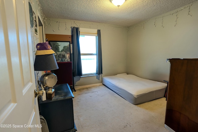 bedroom featuring carpet floors, baseboards, and a textured ceiling