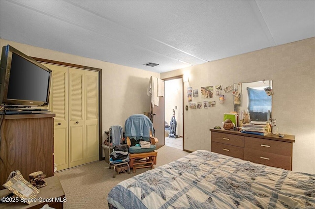 bedroom featuring a closet, visible vents, and light colored carpet