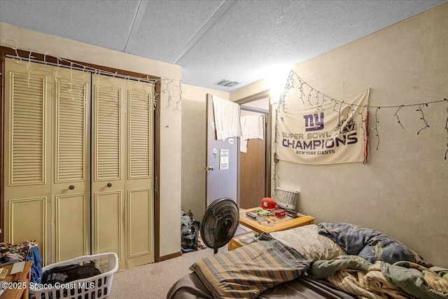 carpeted bedroom with a closet, visible vents, and a textured ceiling