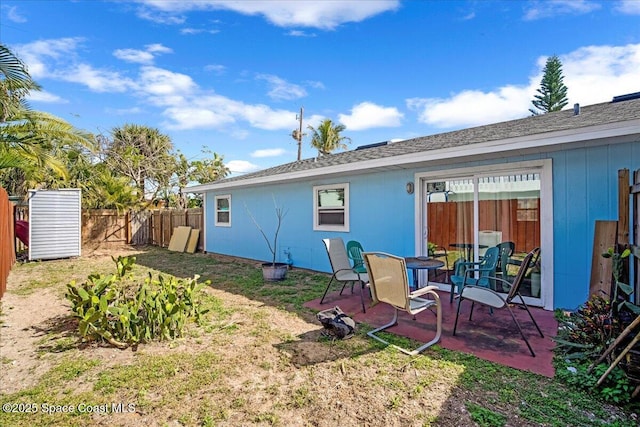 rear view of property featuring a patio, fence, and an outdoor structure