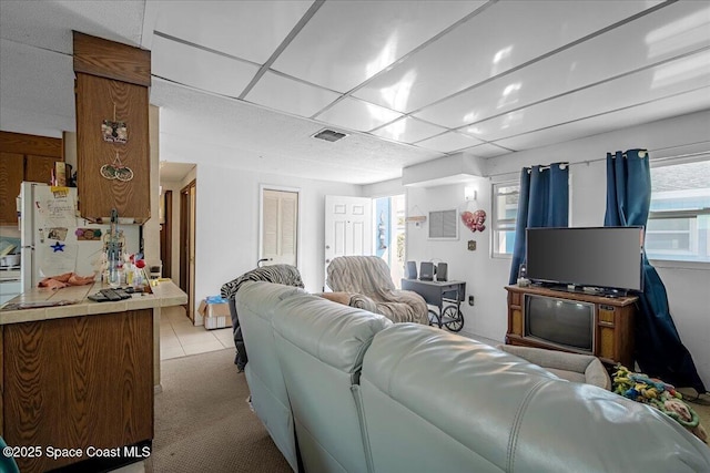 living room featuring visible vents, plenty of natural light, and a paneled ceiling