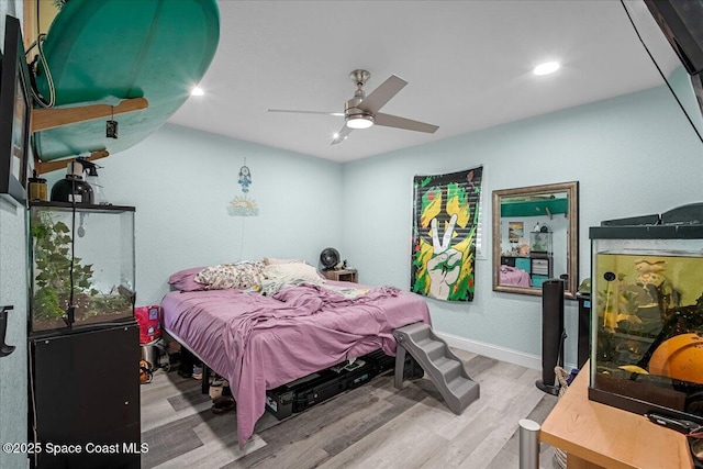 bedroom featuring baseboards, wood finished floors, and a ceiling fan