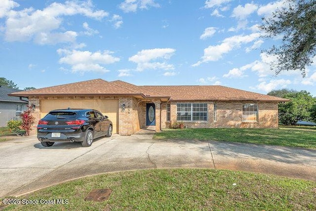 ranch-style home featuring driveway, brick siding, an attached garage, and a front yard