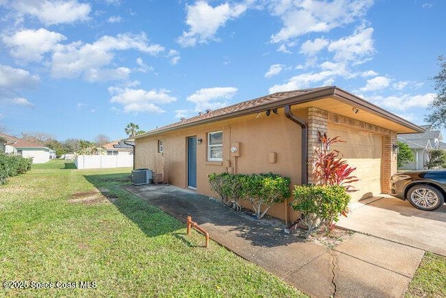 view of property exterior with a garage, driveway, cooling unit, a yard, and stucco siding