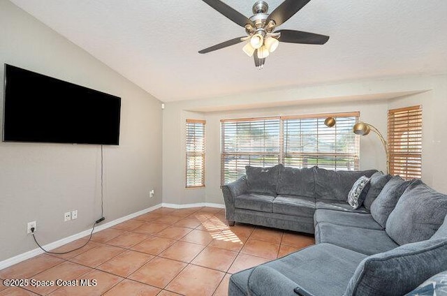 living area with light tile patterned floors, baseboards, lofted ceiling, ceiling fan, and a textured ceiling